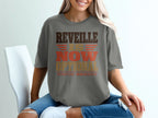 A person wears a gray t-shirt featuring the text REVEILLE IS NOW OPTIONAL EFFECTIVE IMMEDIATELY.