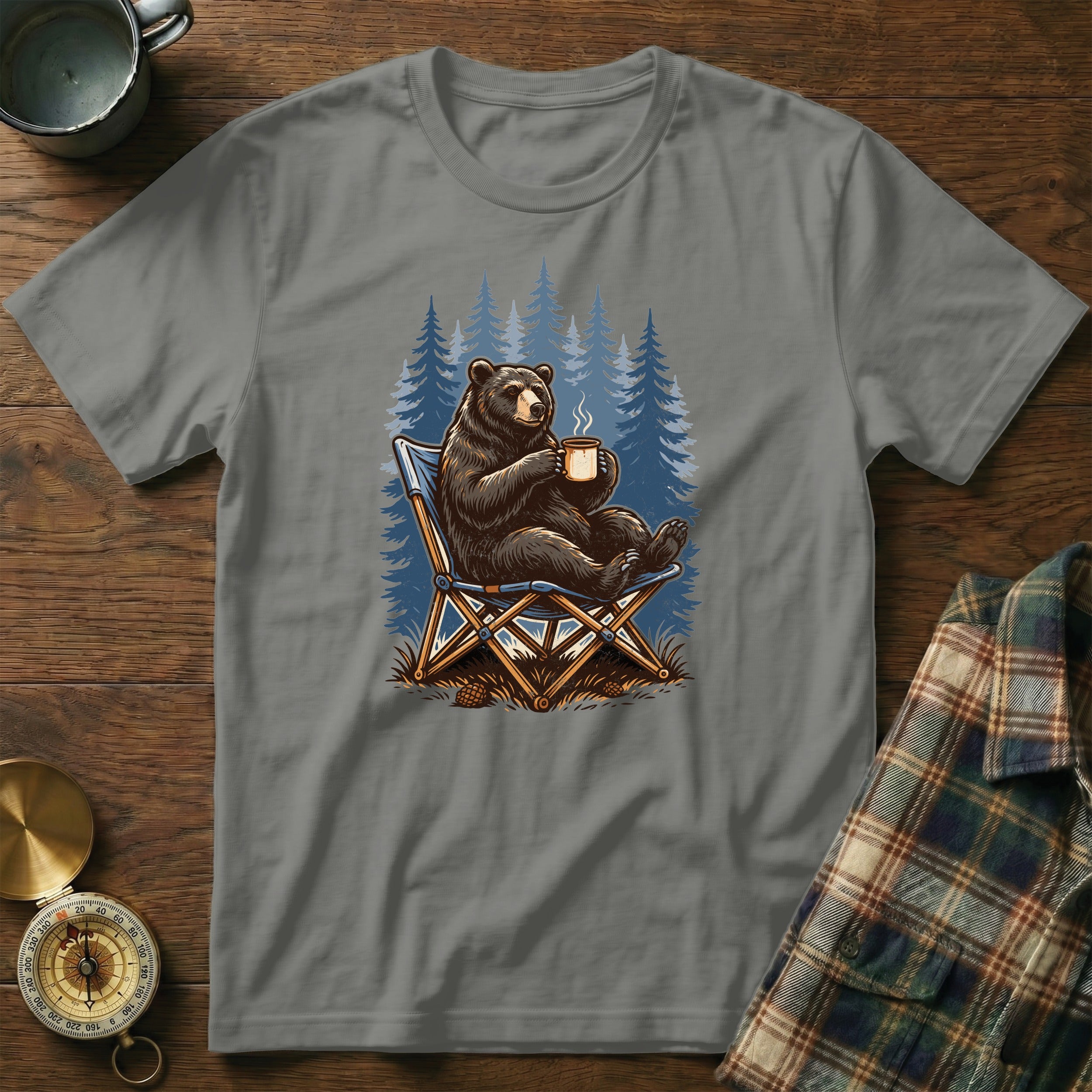 Bear sitting in a camping chair with a mug, forest background.