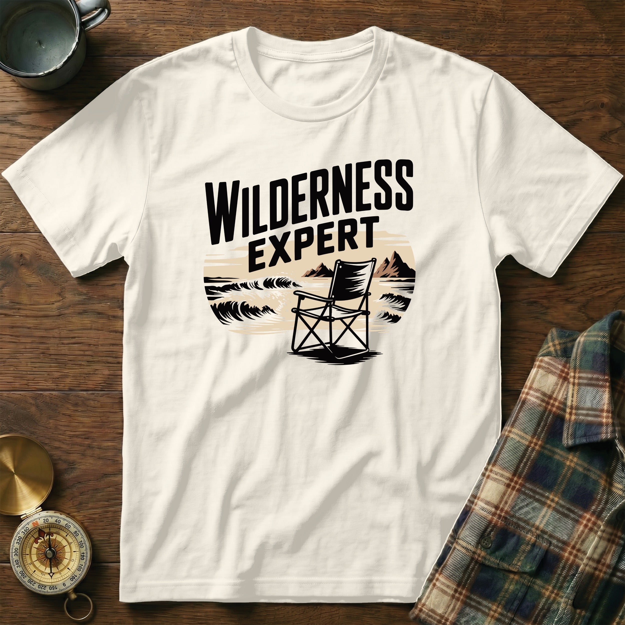 Cream t-shirt with "WILDERNESS EXPERT" graphic featuring a chair on a beach.