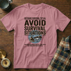 Pink t-shirt with "AVOID SURVIVAL SITUATIONS" text and wilderness graphic.