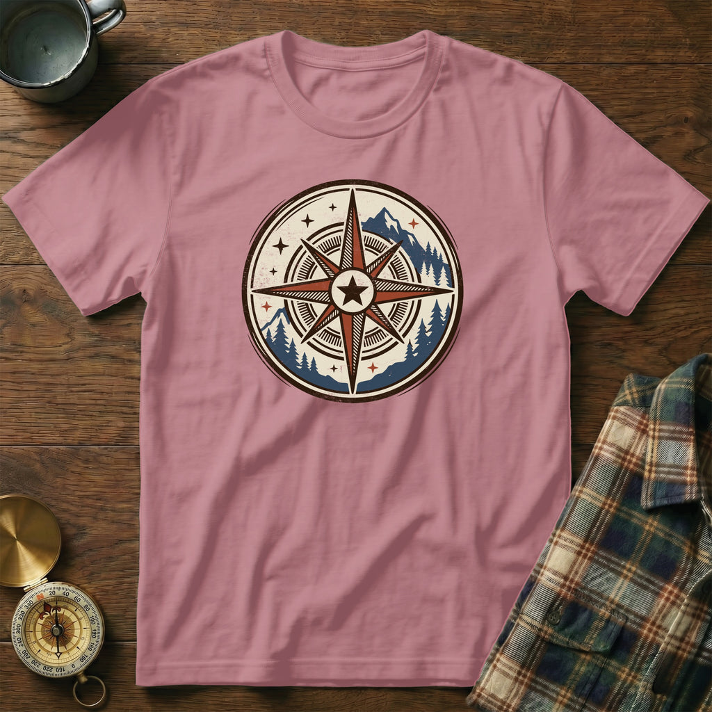 Pink t-shirt with a circular graphic of a compass, mountains, and trees.