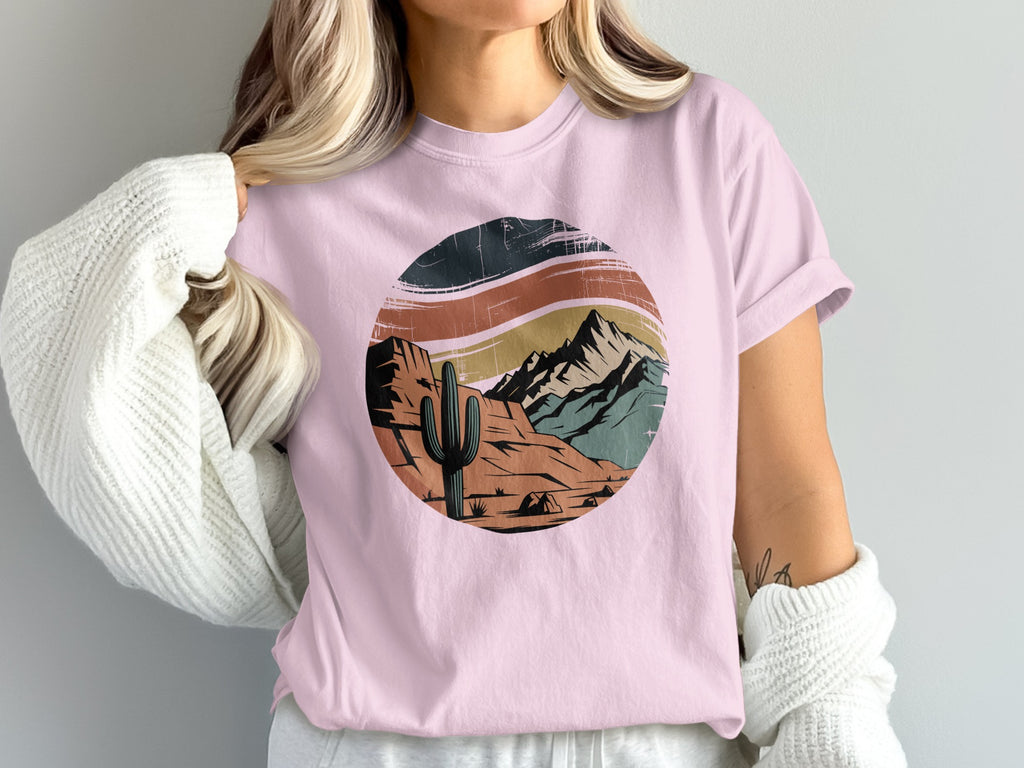 Pink t-shirt with desert mountain sunset graphic.