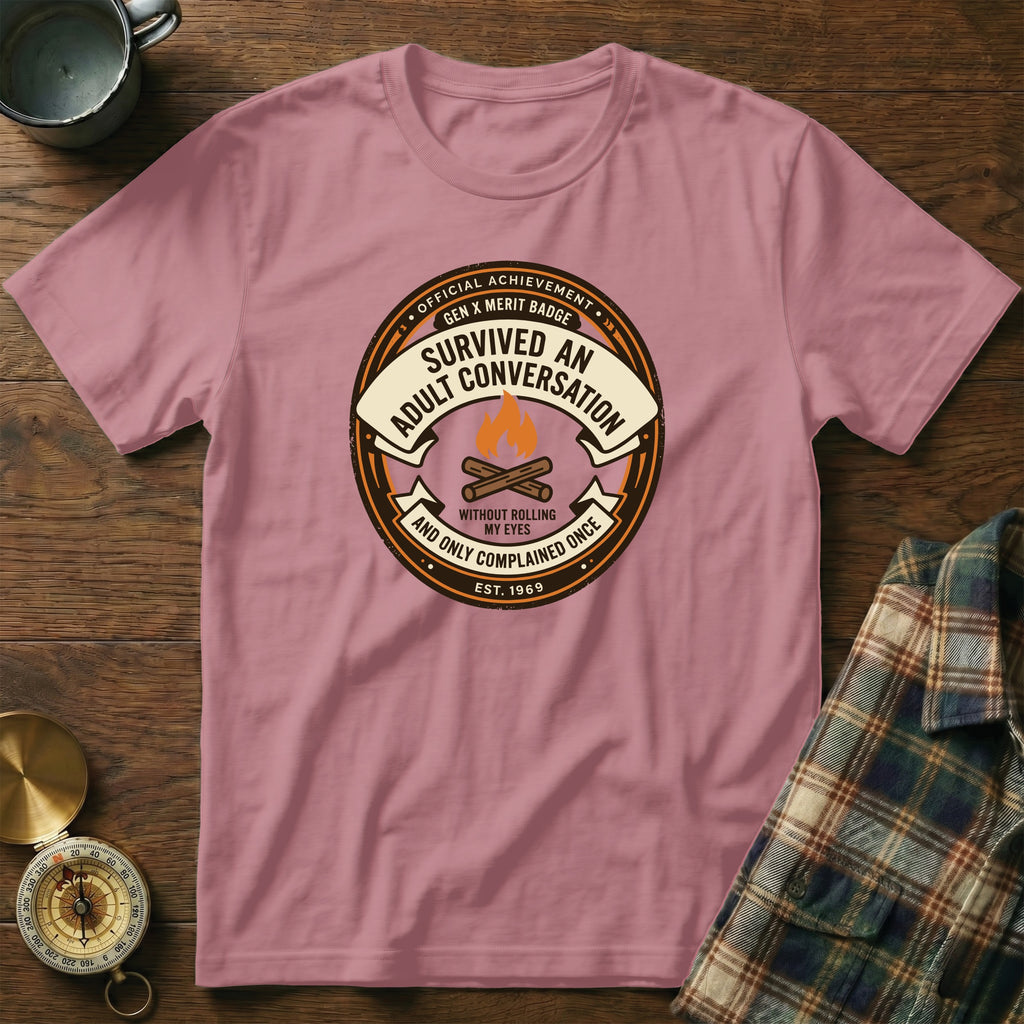 "Adult Conversation" merit badge t-shirt with "Est. 1969" and campfire graphic.