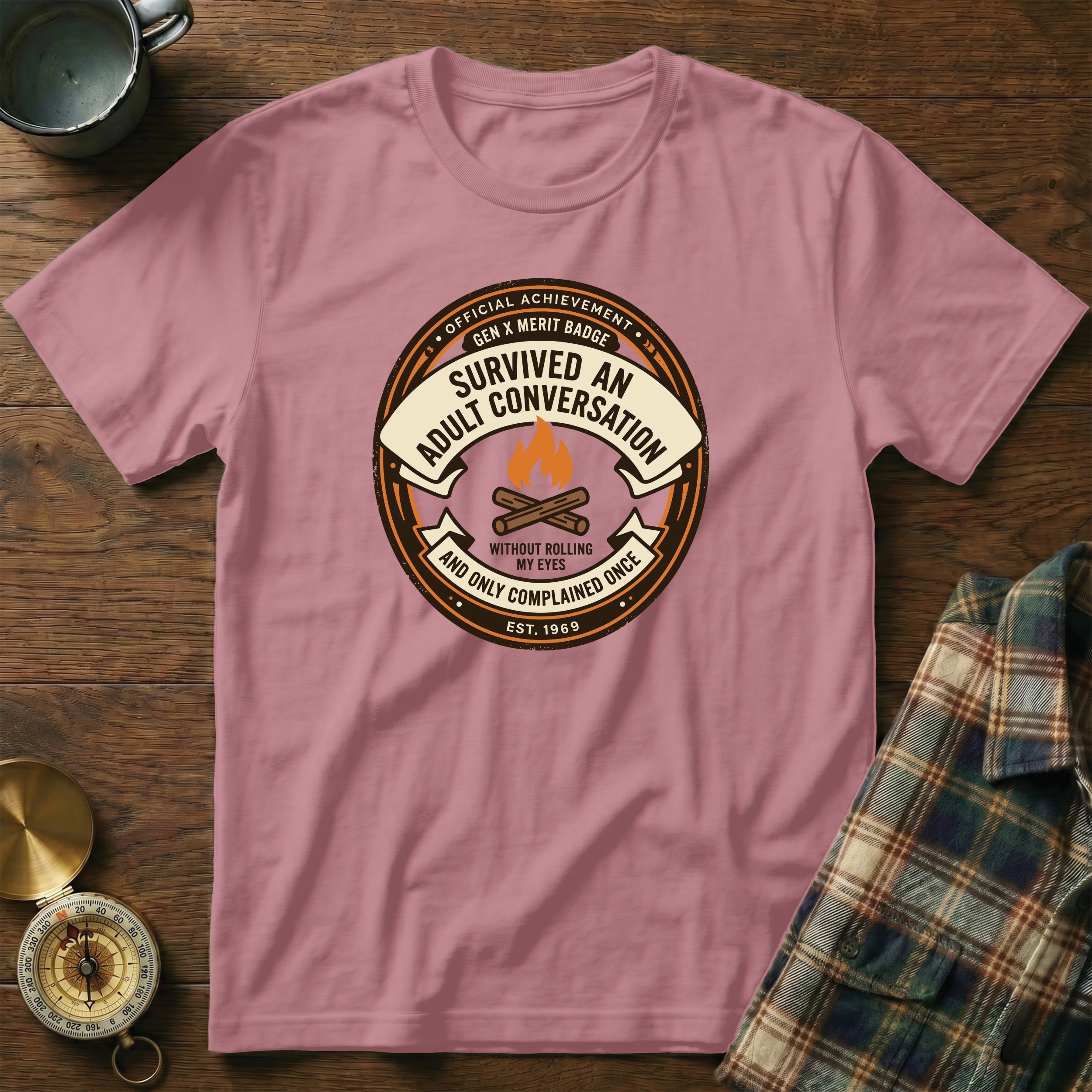 "Adult Conversation" merit badge t-shirt with "Est. 1969" and campfire graphic.