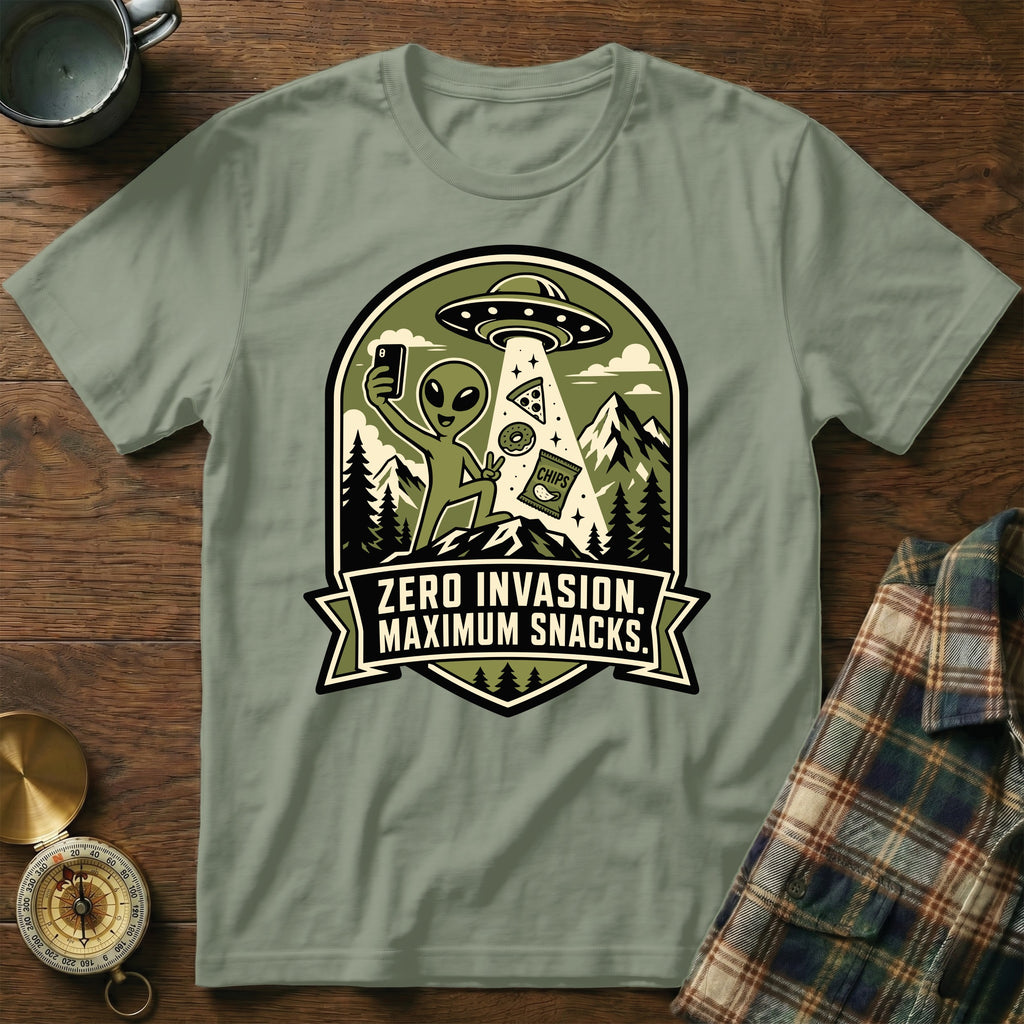 Graphic t-shirt featuring an alien taking a selfie with snacks and text "ZERO INVASION. MAXIMUM SNACKS."