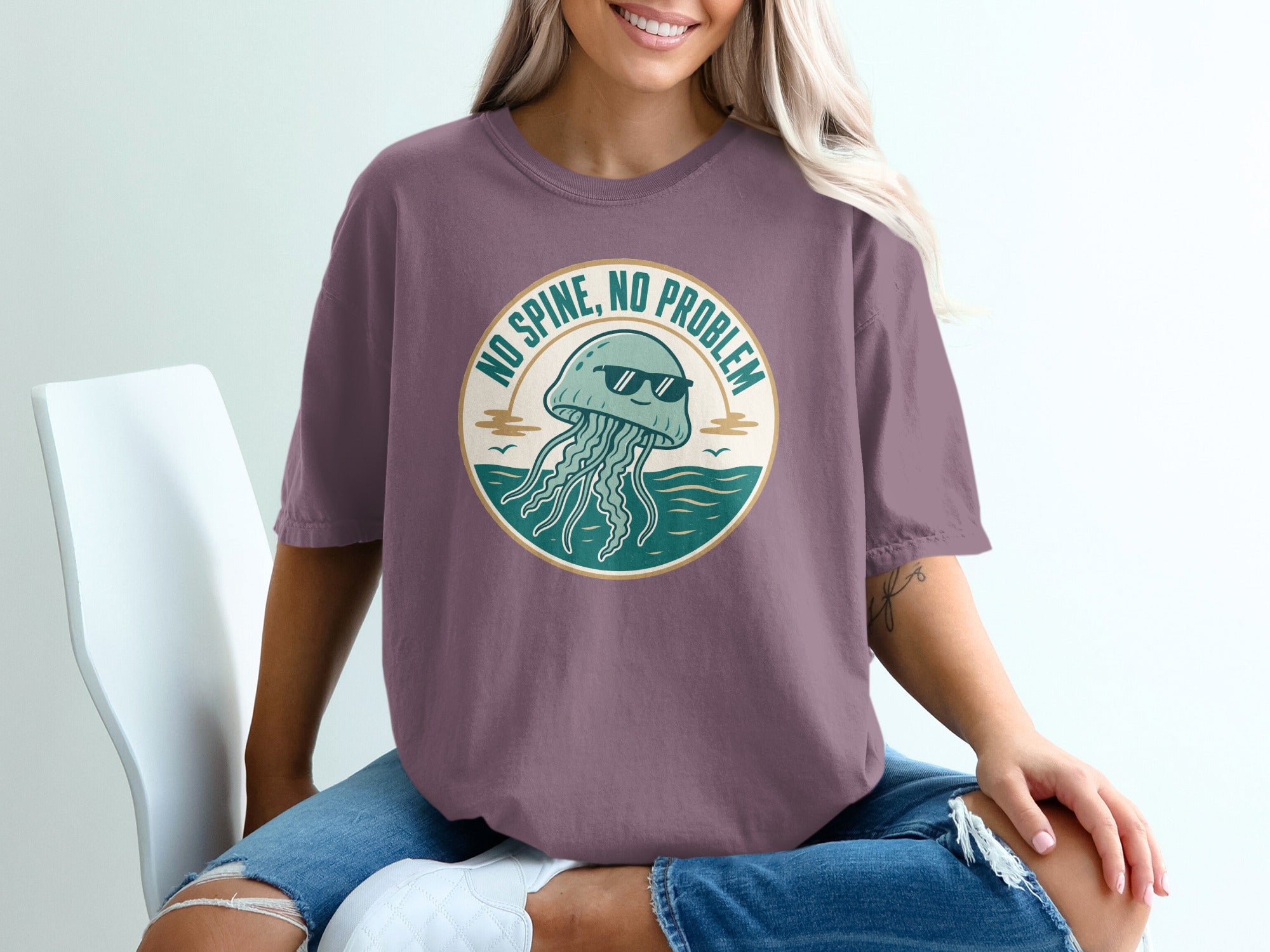 Purple t-shirt with graphic of sunglasses-wearing jellyfish and text "No Spine, No Problem."