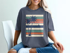 Dark blue t-shirt with a vintage sunset, palm trees, and stripes graphic.