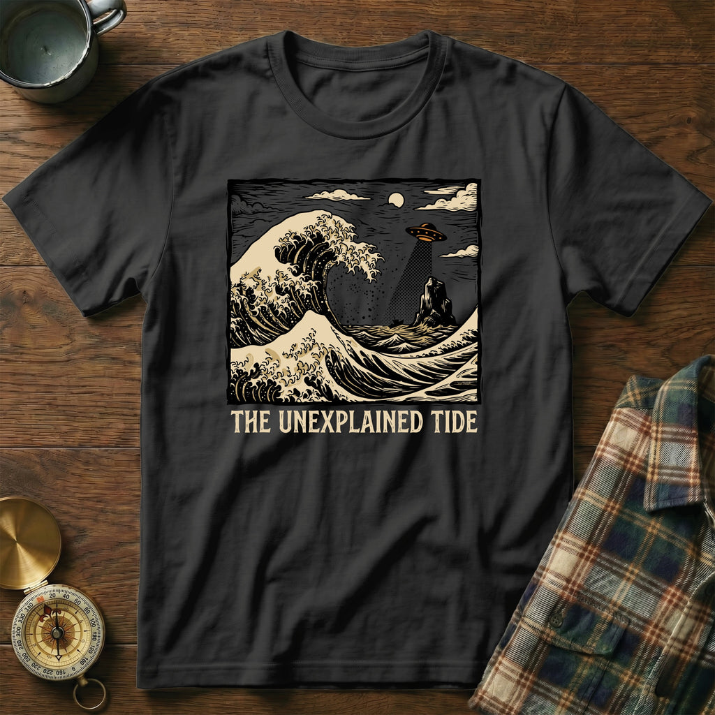Black t-shirt with "The Unexplained Tide" text over a wavy ocean and UFO scene.