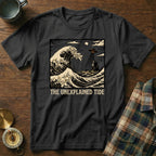 Black t-shirt with "The Unexplained Tide" text over a wavy ocean and UFO scene.