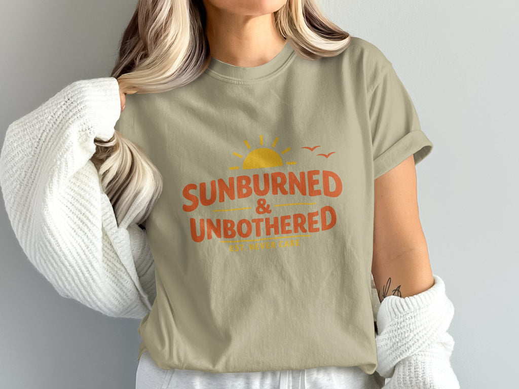 Tan t-shirt with orange text "SUNBURNED & UN<bos>BOTHERED" and a sun graphic.