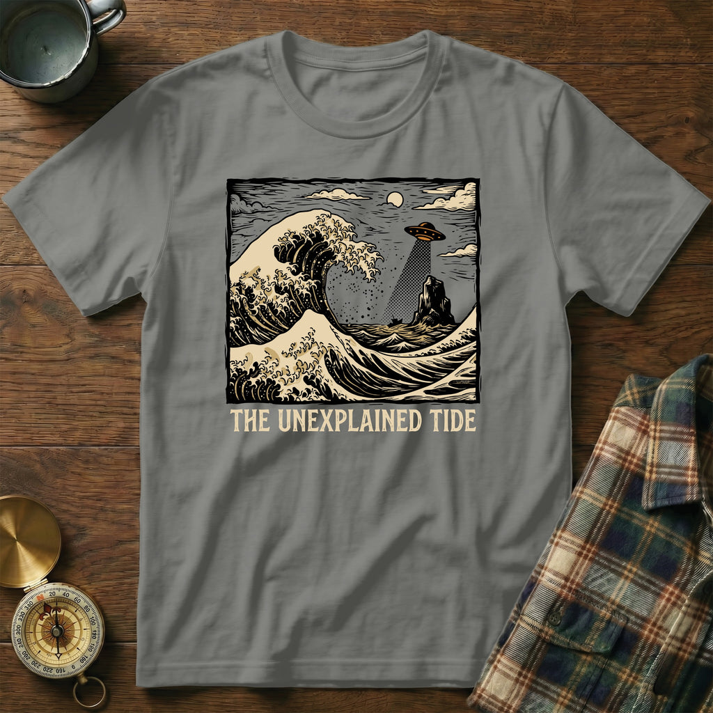 The Unexplained Tide t-shirt features a UFO hovering over waves and a rocky island.
