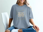 Blue t-shirt with "This Isn't Paradise, You Just Visited" text and wavy lines.