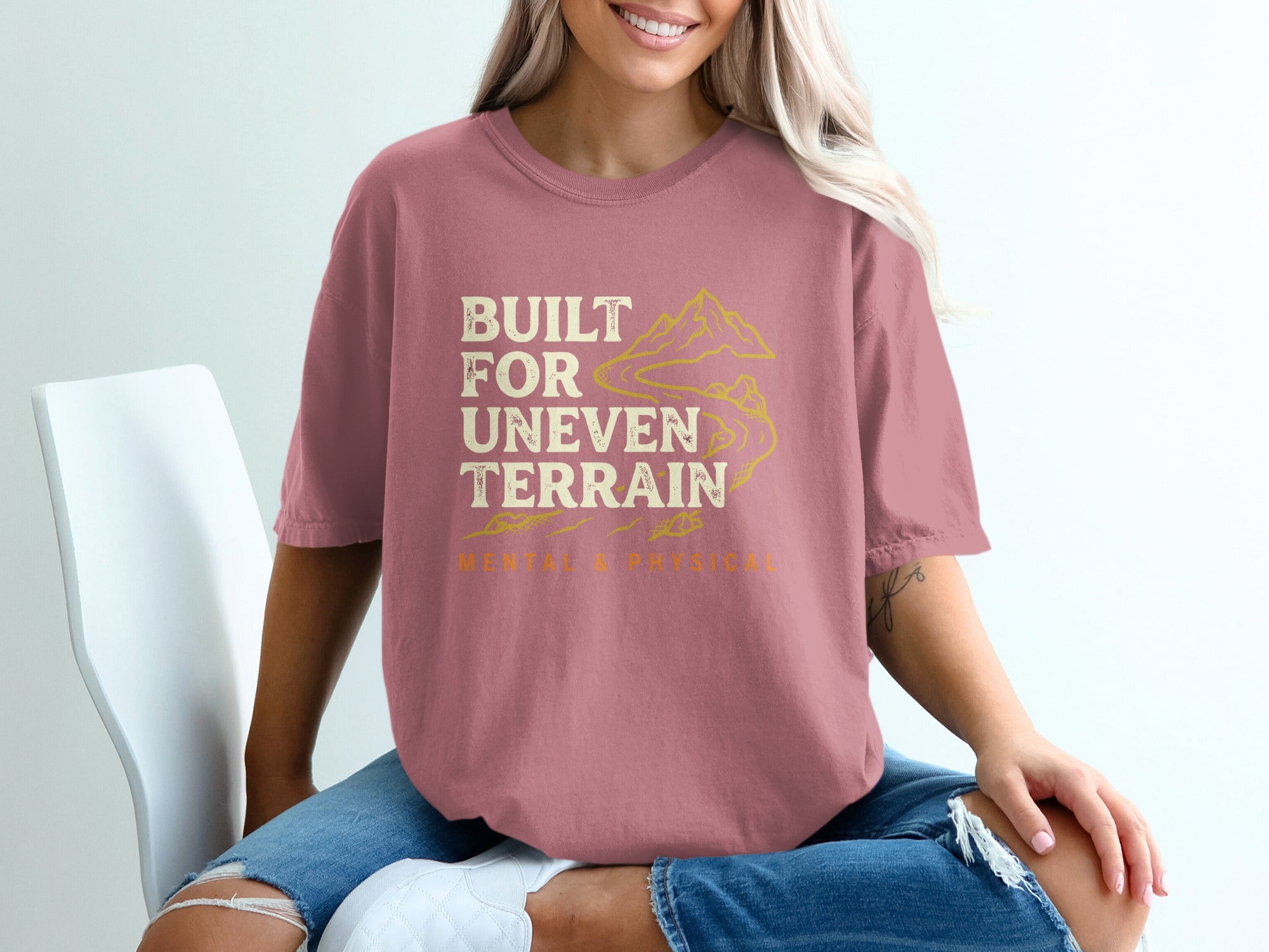 Pink t-shirt with "BUILT FOR UNEVEN TERRAIN" and mountain graphic.