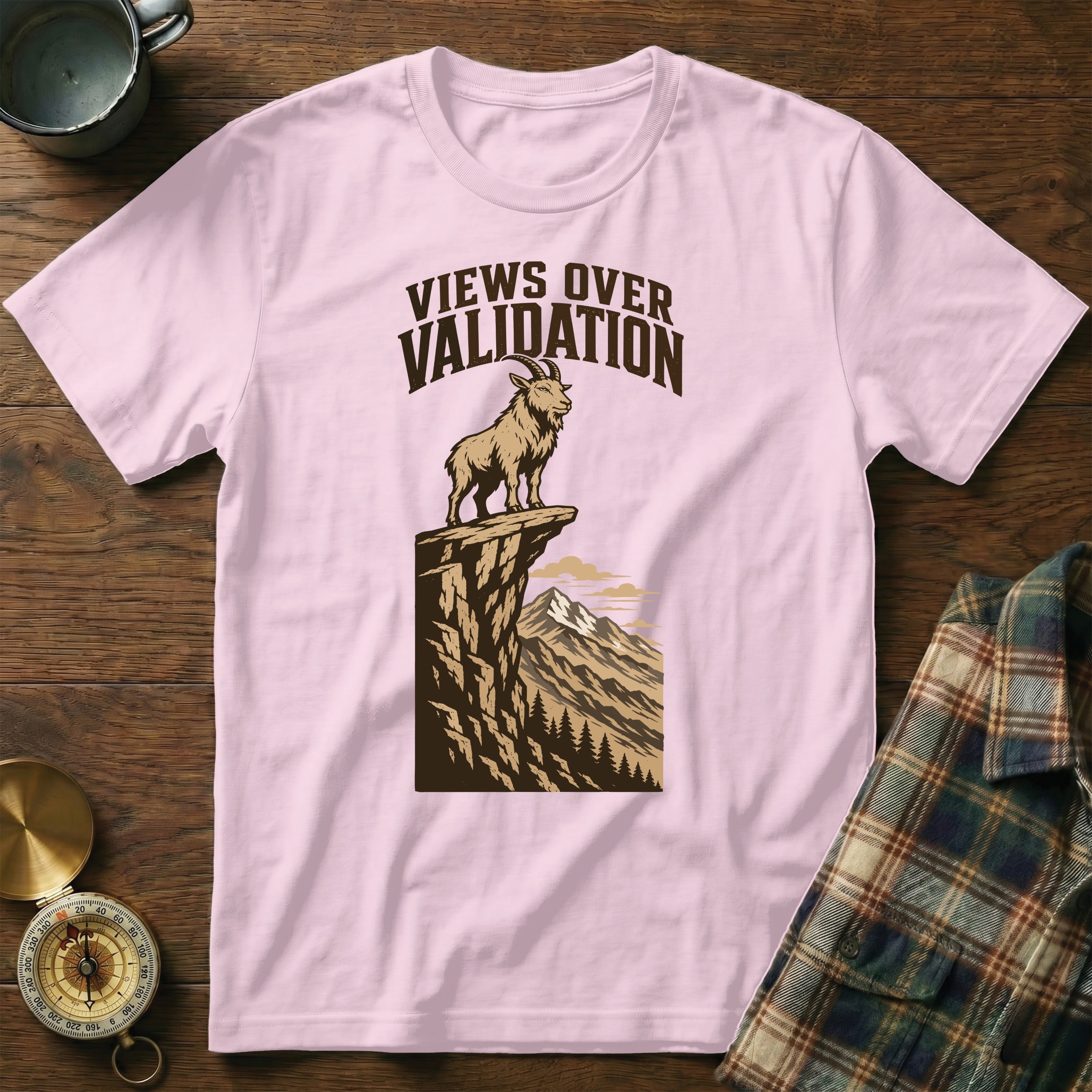 Pink t-shirt with illustration of goat on cliff, "Views Over Validation" text.