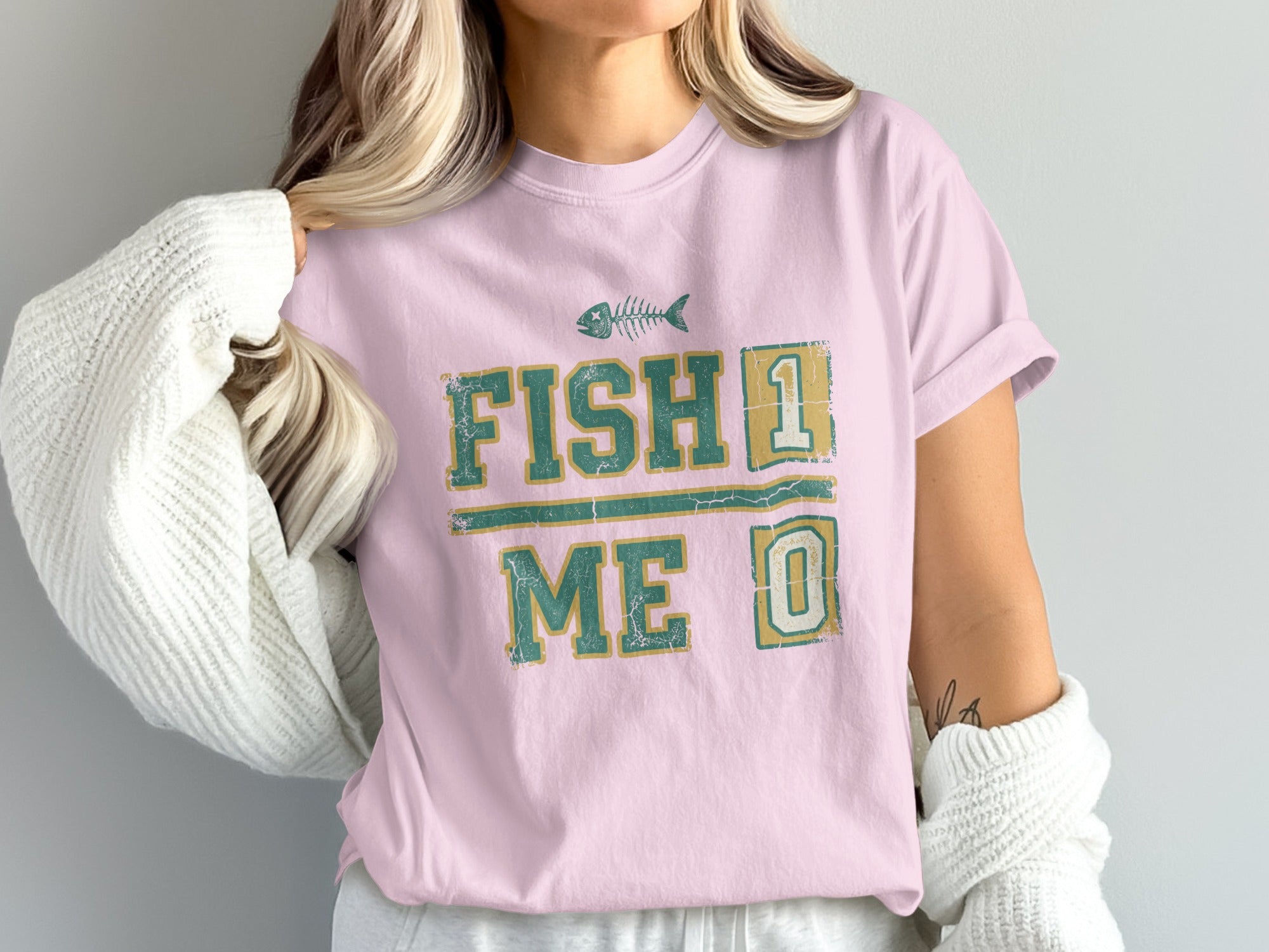Pink t-shirt with "FISH 1 ME 0" text and fish skeleton graphic.