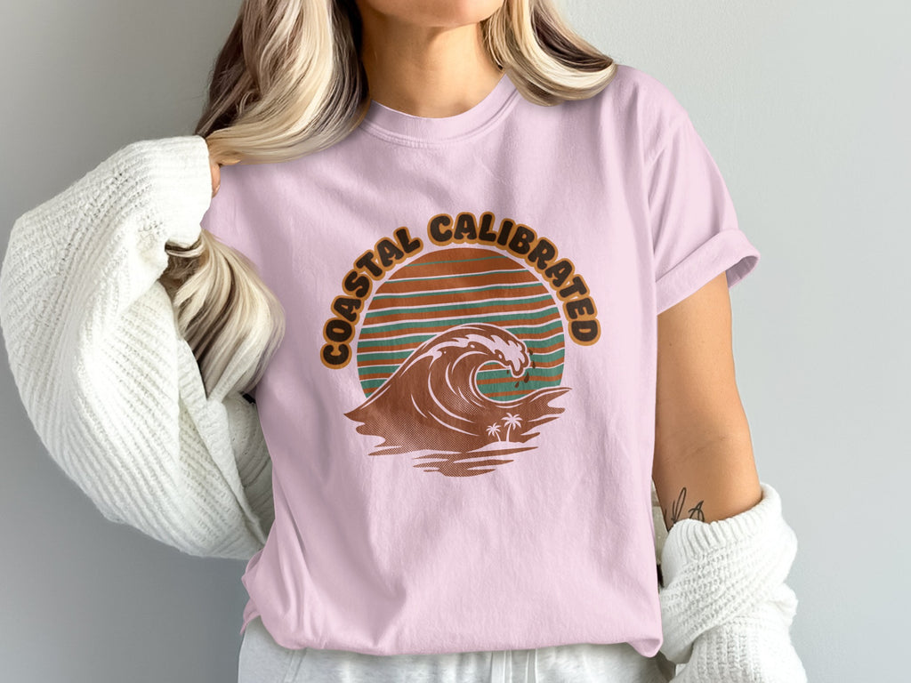 Pink t-shirt with "Coastal Calibrated" text and a wave graphic.