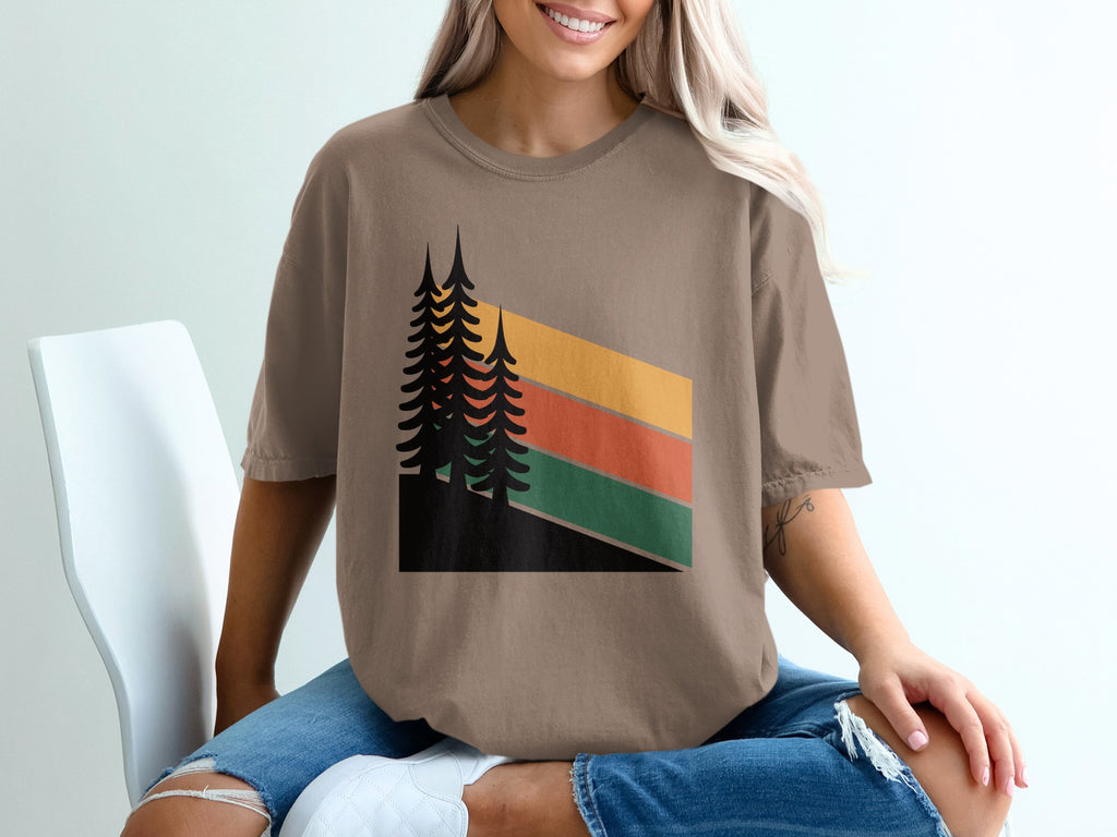 Brown t-shirt with abstract geometric trees and colored stripes.