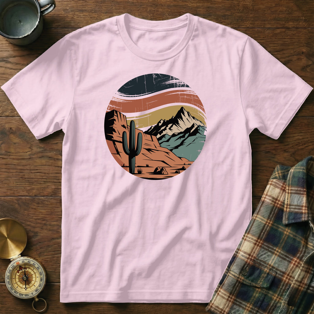 Pink t-shirt with desert landscape graphic featuring cactus and mountains.