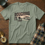 T-shirt with "ROUGHING IT." graphic featuring a beach chair, waves, and mountains.