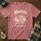 Dusty pink crewneck t-shirt featuring a vintage mountain graphic and the text Mountain Sunrise hike. Sunset arrival.