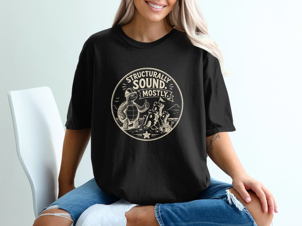 Black t-shirt with a graphic of a turtle giving a thumbs up next to a sandcastle.