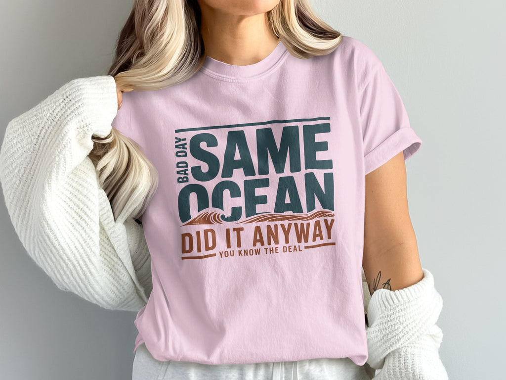 Pink t-shirt with "Same Ocean Did It Anyway" text and wave graphic.