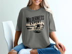 T-shirt with "Wilderness Expert" text and a beach scene with a chair.