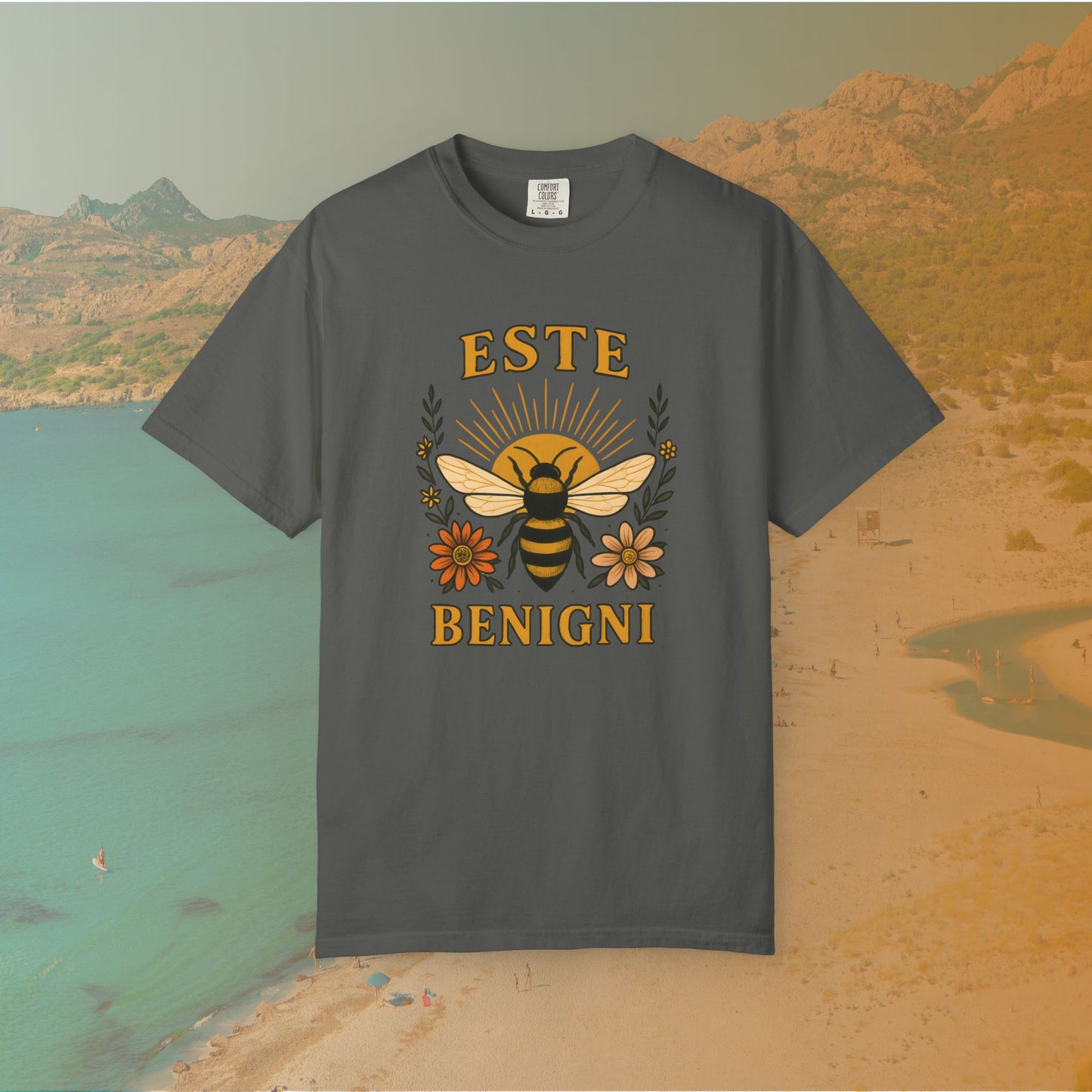 grey t-shirt Vintage-style graphic tee featuring a large, central honey bee with sunburst wings, flanked by retro flowers. The Latin words "ESTE BENIGNI" for "BEE KIND" are printed above and below the design.