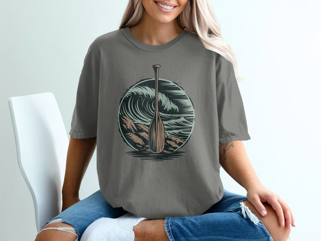 T-shirt graphic: oar and large ocean wave in a circle.