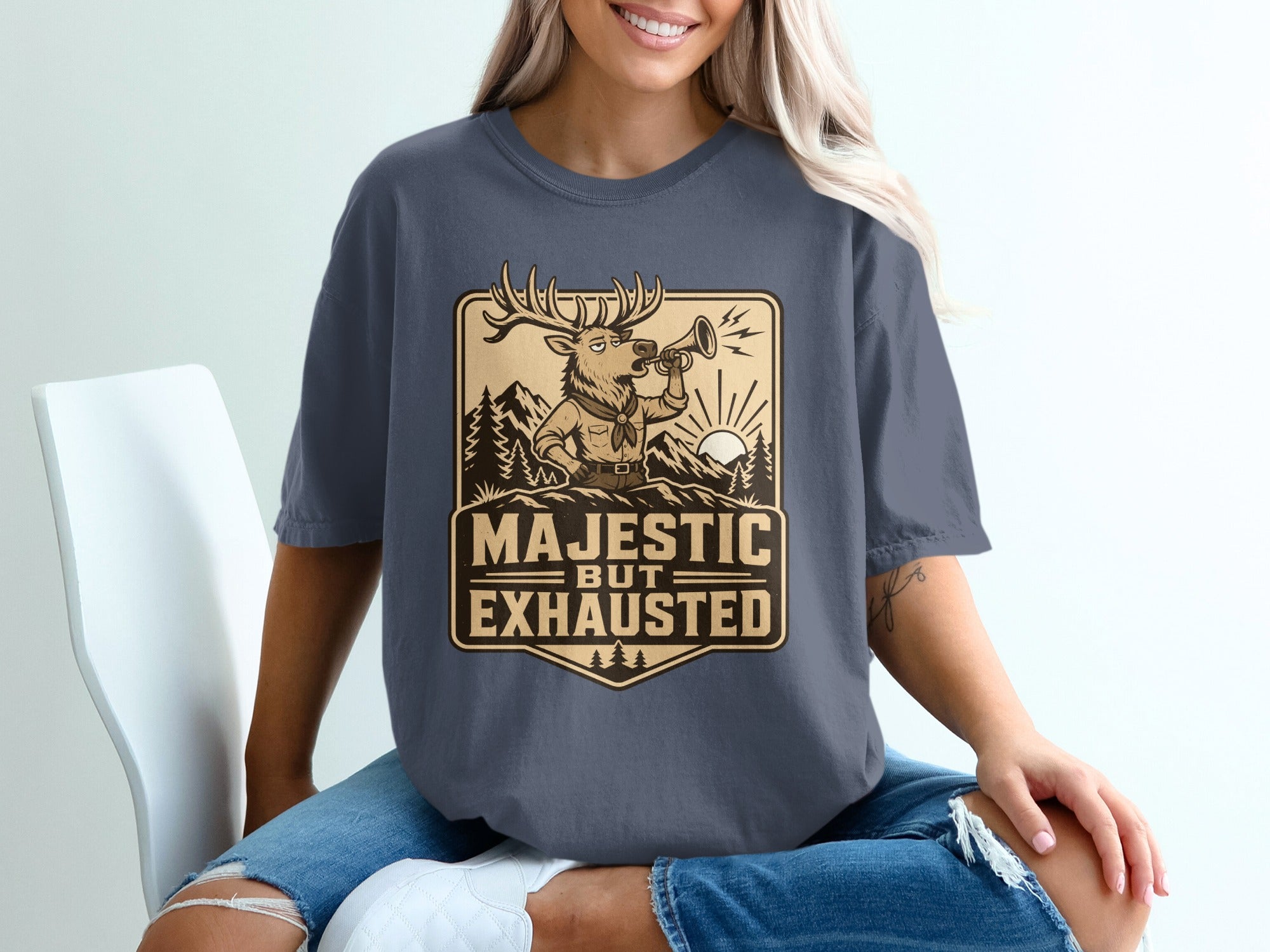 Deer graphic with text "Majestic But Exhausted" on a dark gray t-shirt.