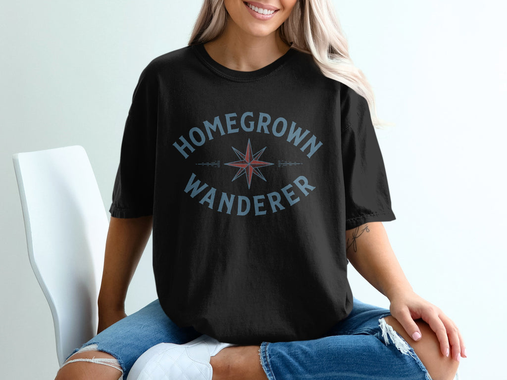 Black t-shirt with blue text "HOMEGROWN WANDERER" and a compass graphic.