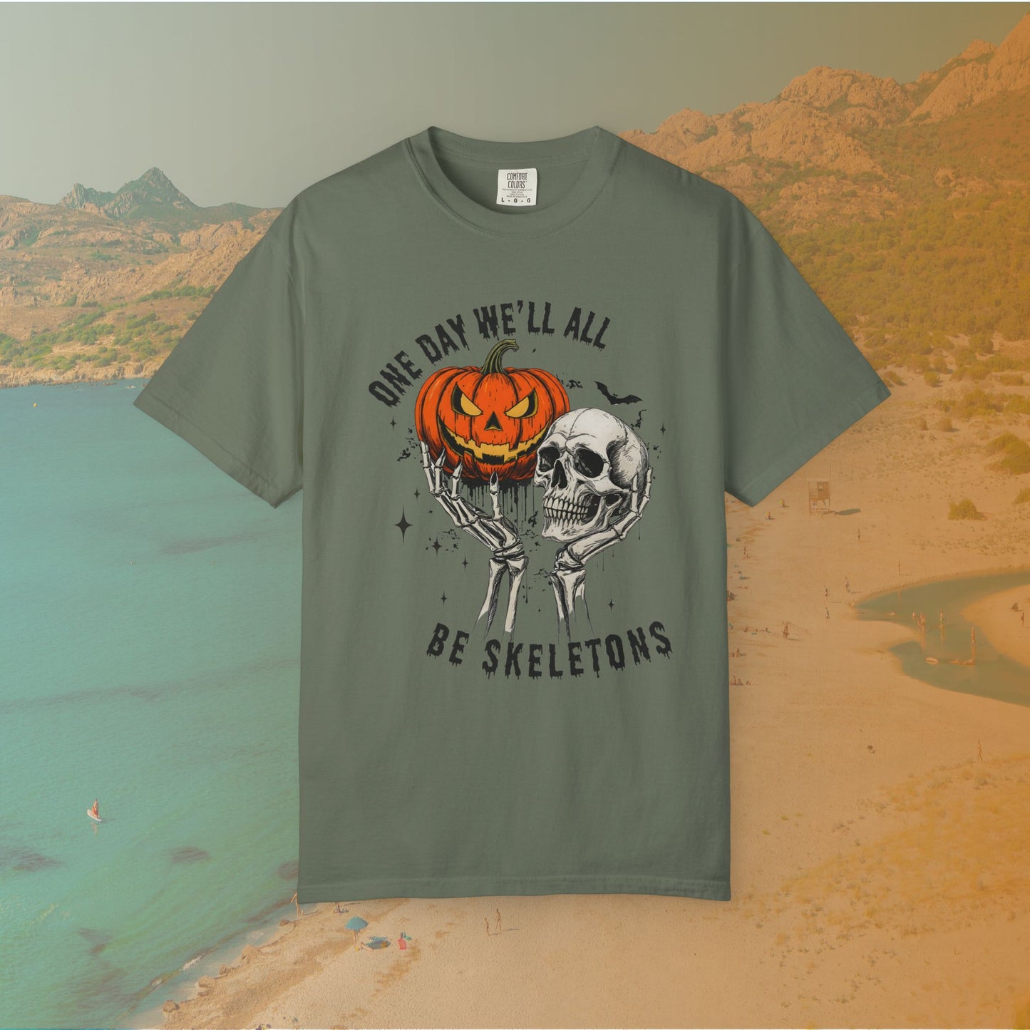 Skeleton hands holding a jack-o'-lantern and skull with the phrase ‘One Day We’ll All Be Skeletons’ in grunge font