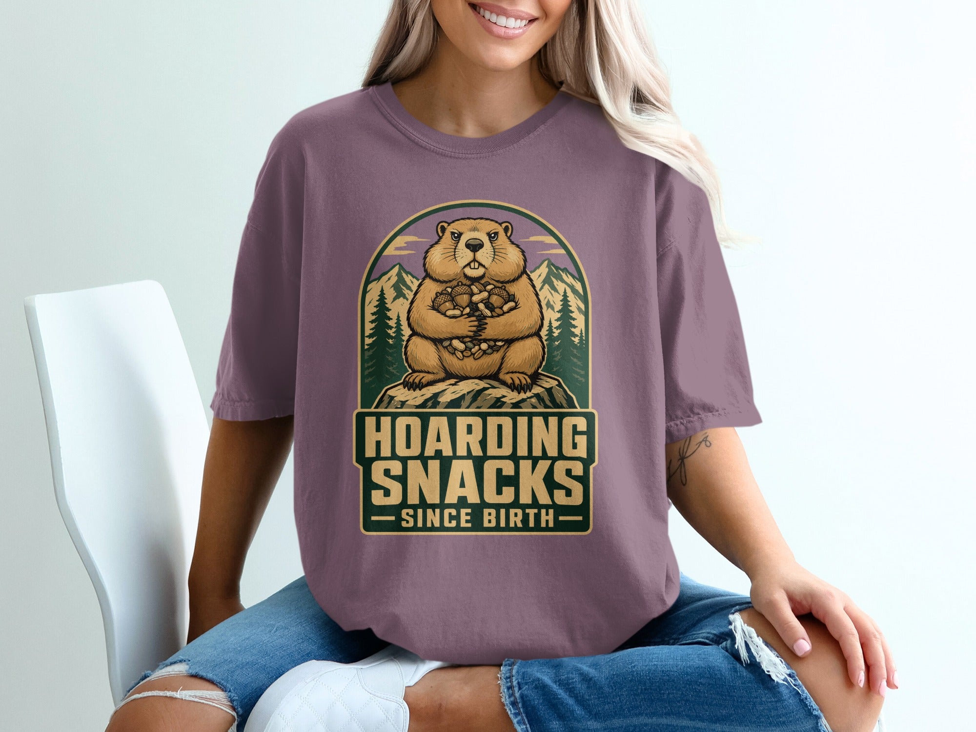 Woodchuck holding acorns with text "Hoarding Snacks Since Birth."