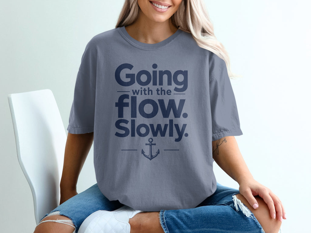 A person wearing a grey t-shirt featuring the text "Going with the flow. Slowly." and an anchor graphic.
