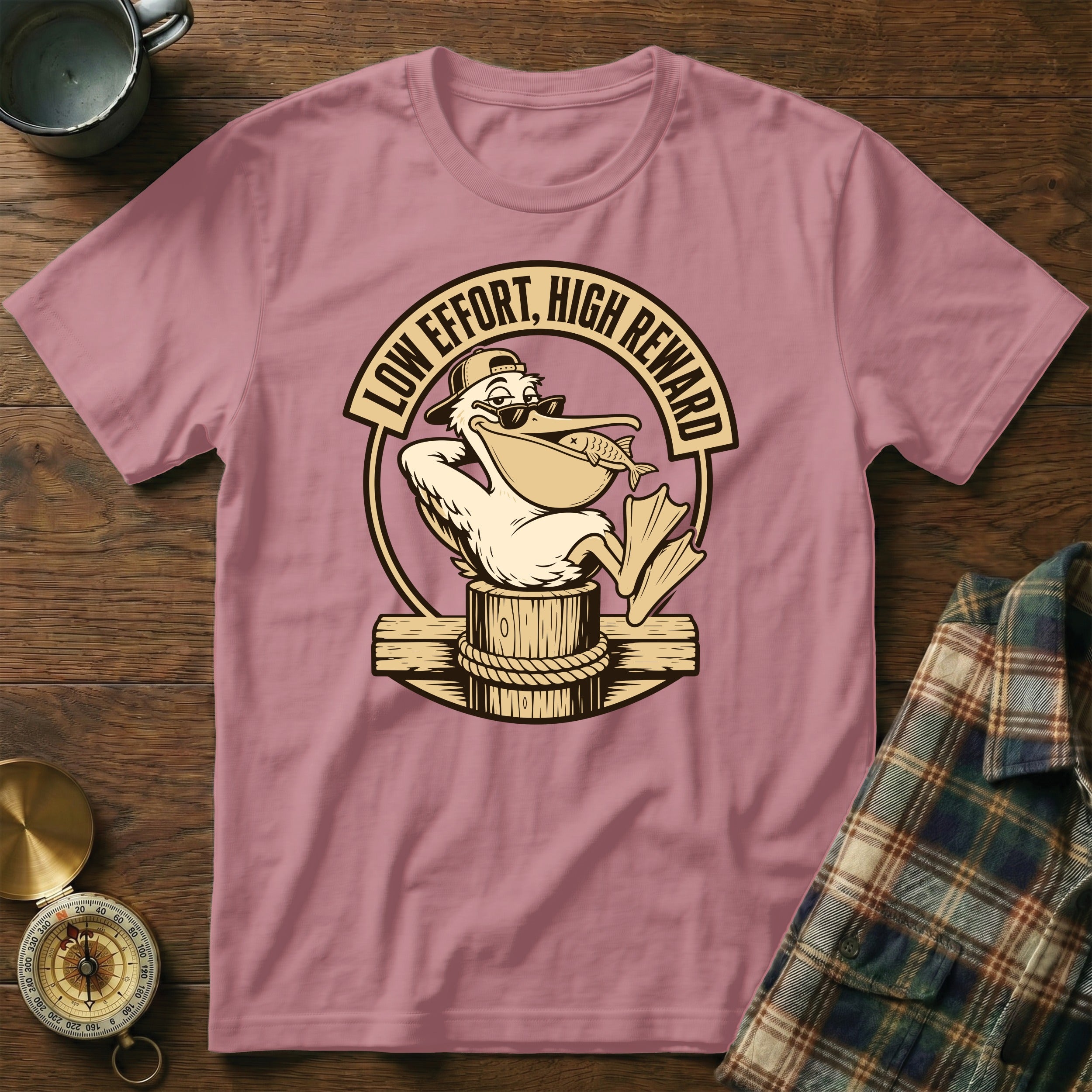 Pink t-shirt with a pelican wearing sunglasses holding a fish, with text "LOW EFFORT, HIGH REWARD".