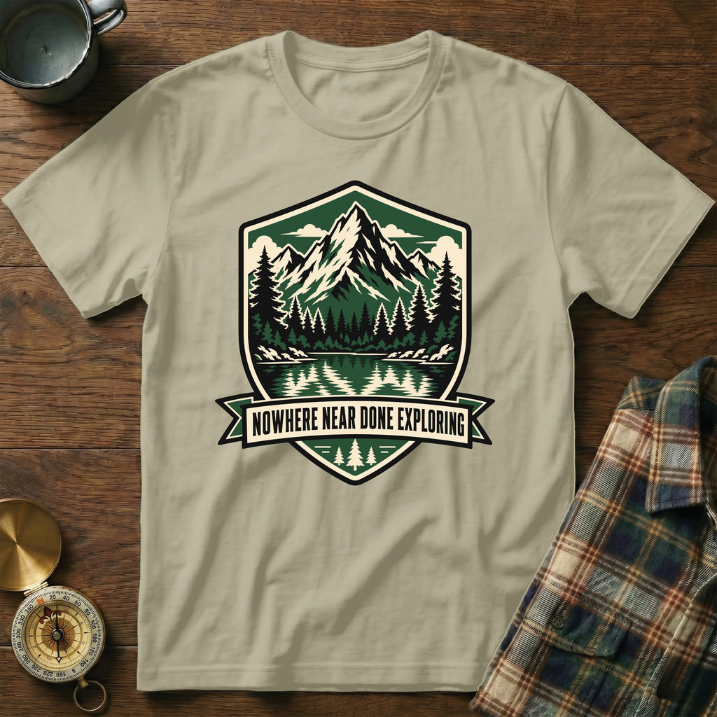 T-shirt with mountain lake forest motif and "NOWHERE NEAR DONE EXPLORING" text.