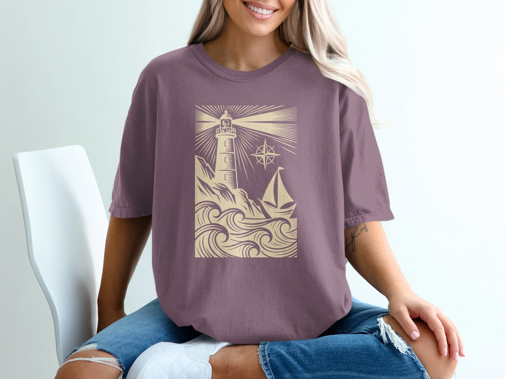 Purple t-shirt with lighthouse, sailboat, and compass design.