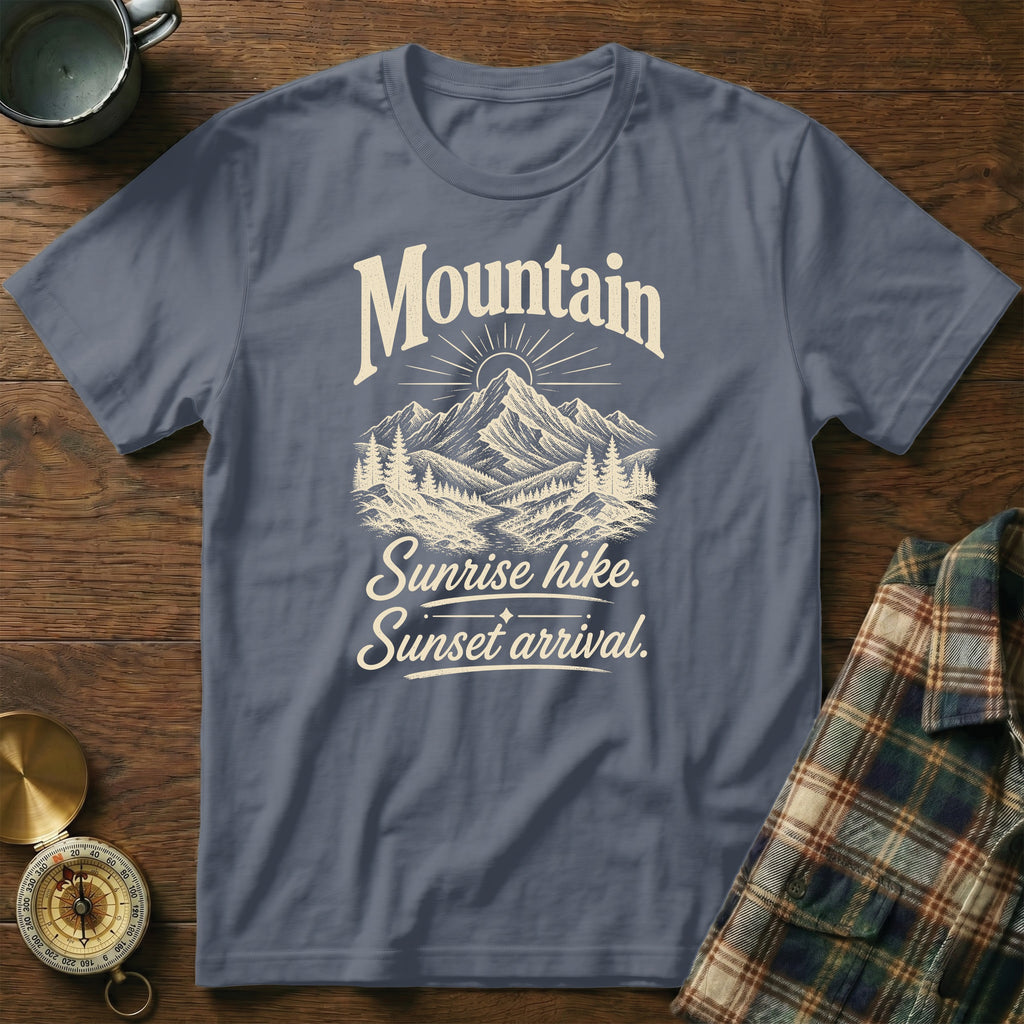 Slate blue t-shirt featuring a mountain, forest graphic, and the text Mountain Sunrise hike, Sunset arrival.