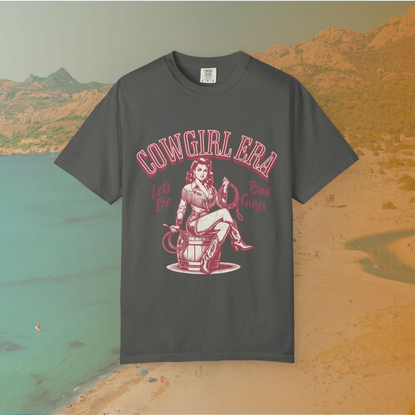 Cowgirl Era pinup T-shirt with a vintage-style illustration of a sassy cowgirl sitting on a barrel holding a lasso. The graphic includes the text "COWGIRL ERA" and "Lets Be Bad Guys.