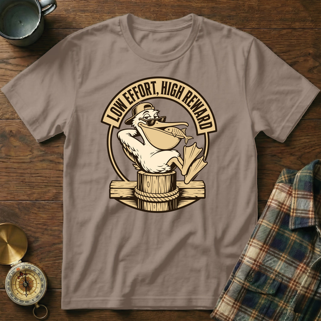 Brown t-shirt with a pelican graphic holding a fish and text "Low Effort, High Reward."
