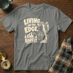 Gray t-shirt with "Living on the Edge, Barely" text and a goat hanging from a cliff.