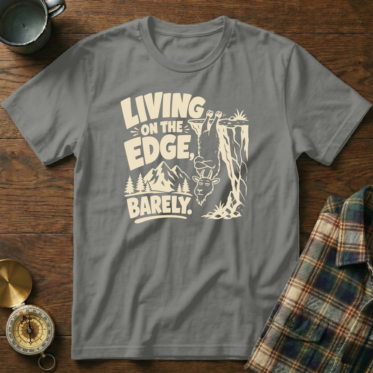Gray t-shirt with "Living on the Edge, Barely" text and a goat hanging from a cliff.