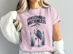 Pink t-shirt with text "Professionally Motionless" and a graphic of a heron.