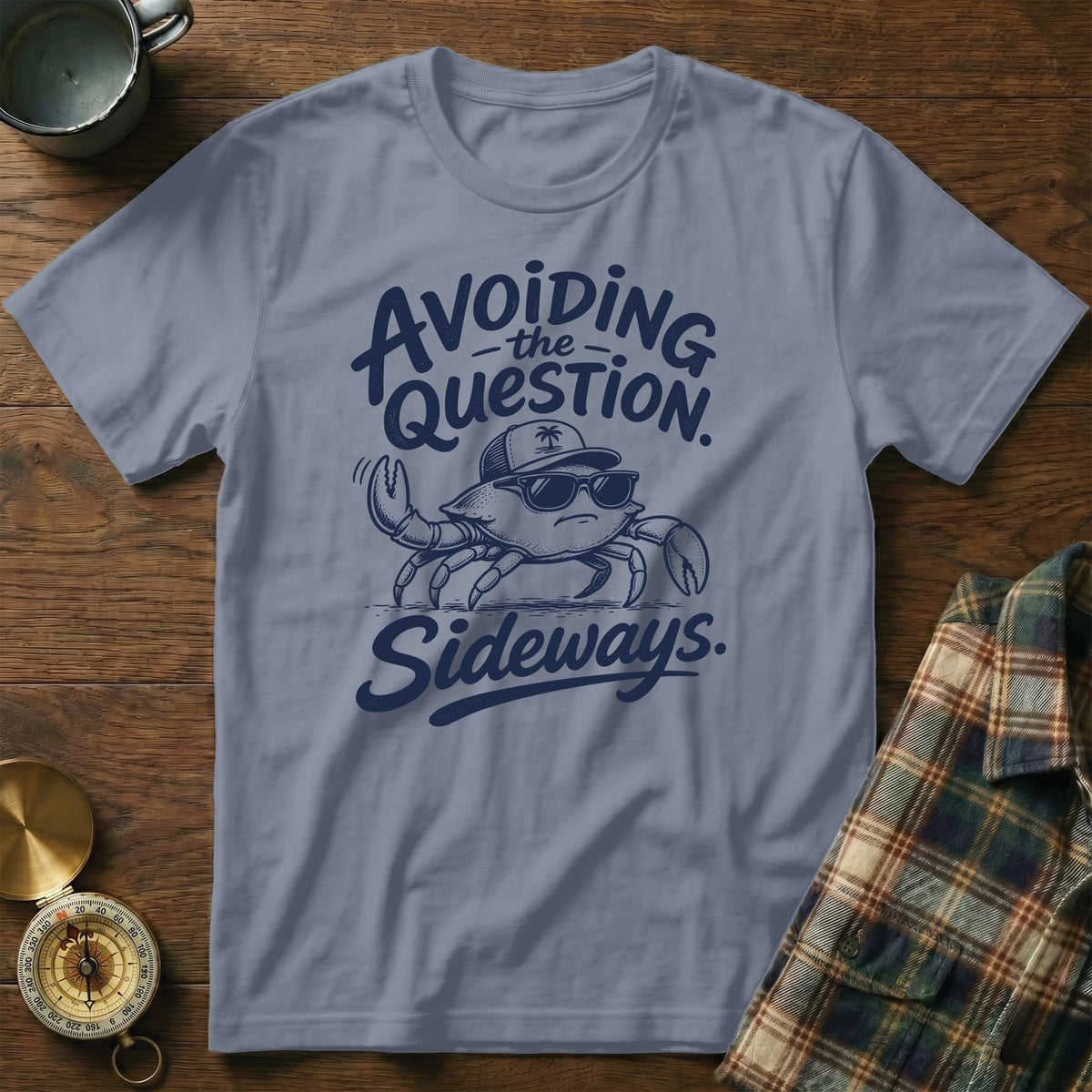 Blue t-shirt featuring a cartoon crab wearing sunglasses and a hat with the text Avoiding the Question Sideways.