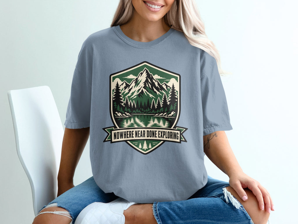 T-shirt with a mountain lake scene and text "Nowhere Near Done Exploring".