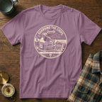 A purple t-shirt featuring a circular graphic with a seagull wearing sunglasses on a cooler.