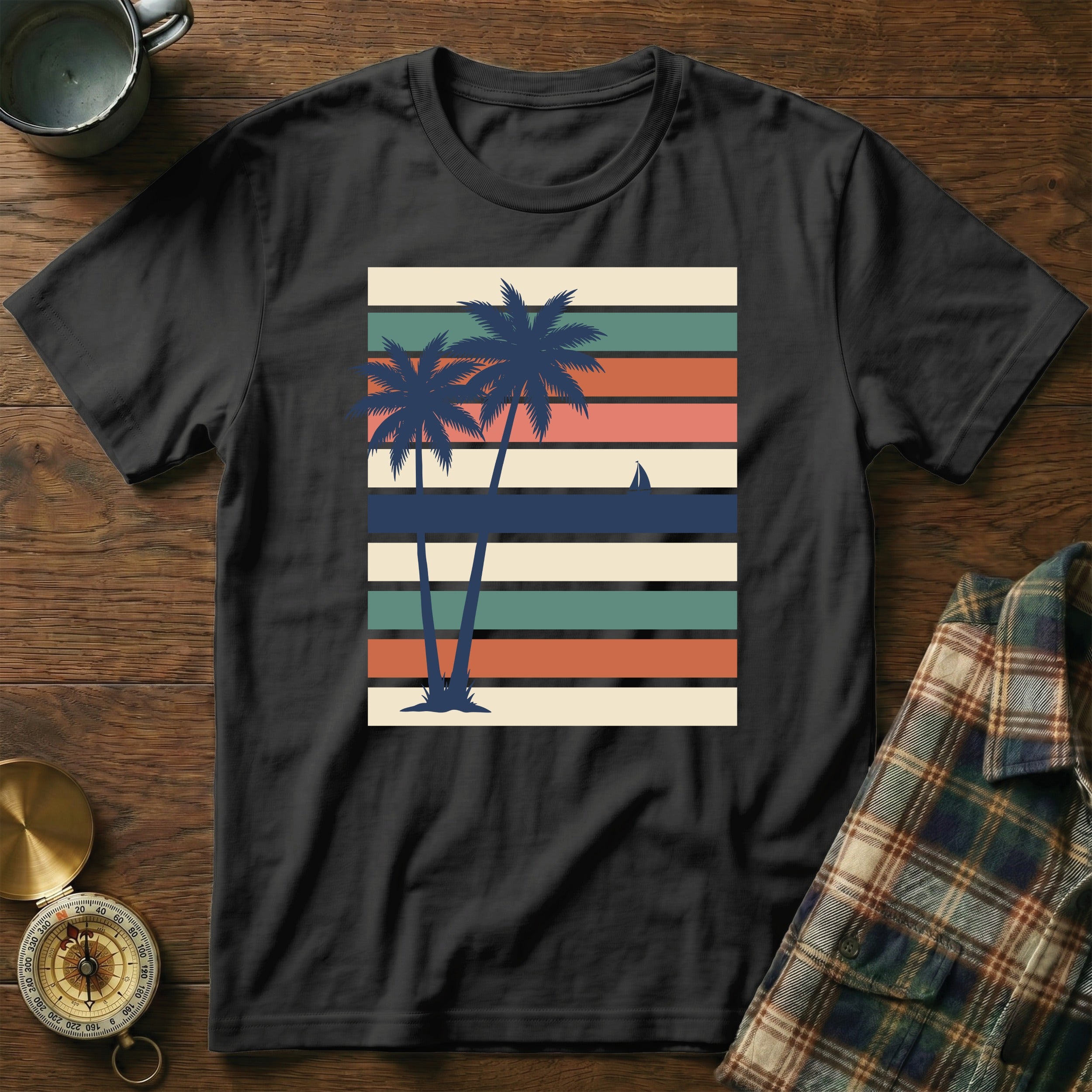 Black t-shirt with vintage palm trees and sunset stripes graphic.