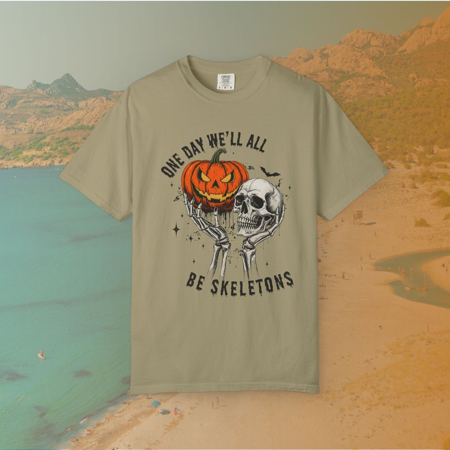 Skeleton hands holding a jack-o'-lantern and skull with the phrase ‘One Day We’ll All Be Skeletons’ in grunge font