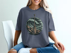 Canoe paddle in circle with waves and rocky shore illustration on gray t-shirt.