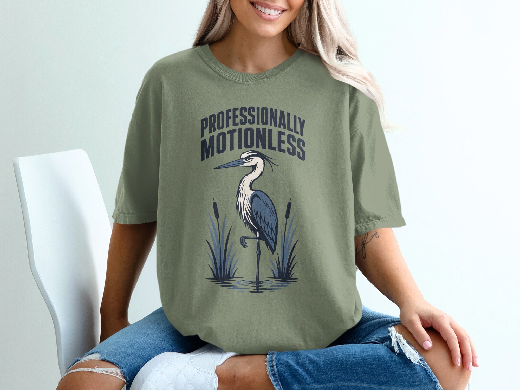 Green t-shirt with a heron graphic and "Professionally Motionless" text.